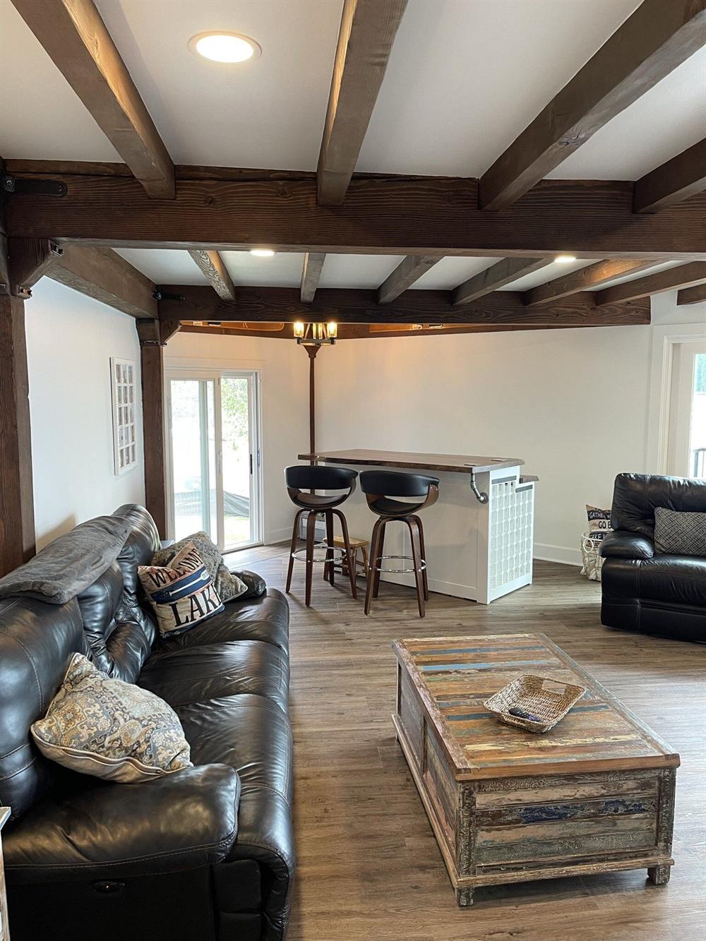 Family room repainted with white walls and stained beams